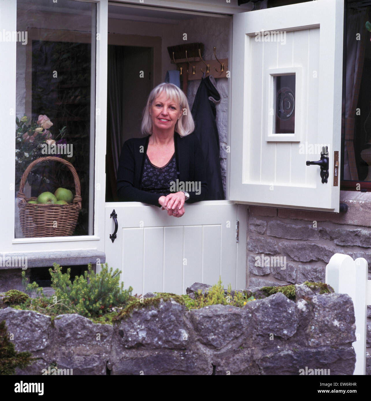 Lächelnde Frau, die aus einer weißen Hütte Tür Stockfoto