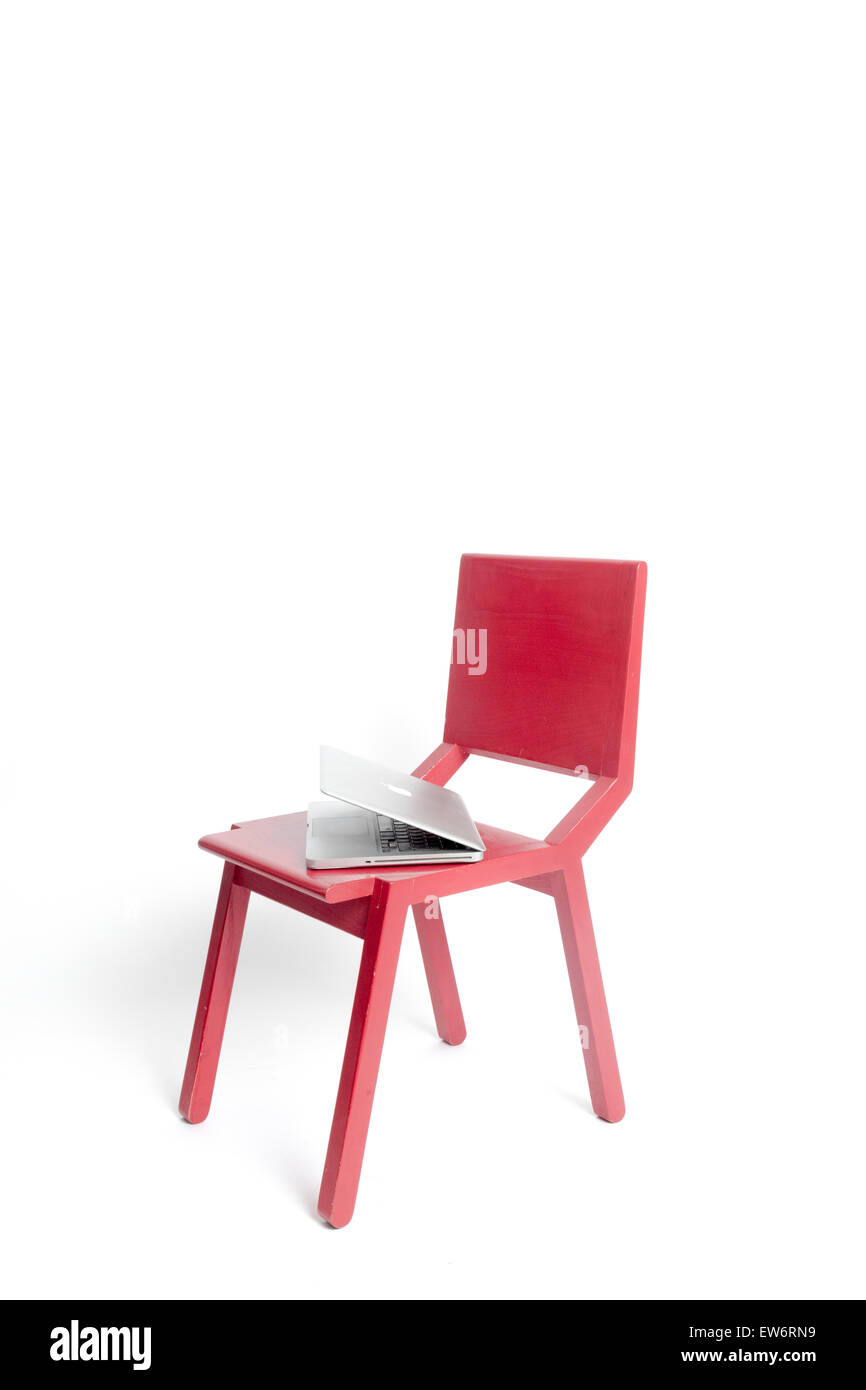 Eine rote modernistischen Designer Holzstuhl mit einem Laptopcomputer Stockfoto