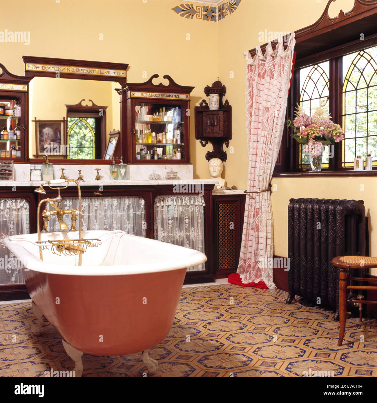 Malte Roll Top Bad in neunziger Jahre edwardianischen Stil Badezimmer mit gemusterten Fliesen und Mahagoni Unterschrank Stockfoto
