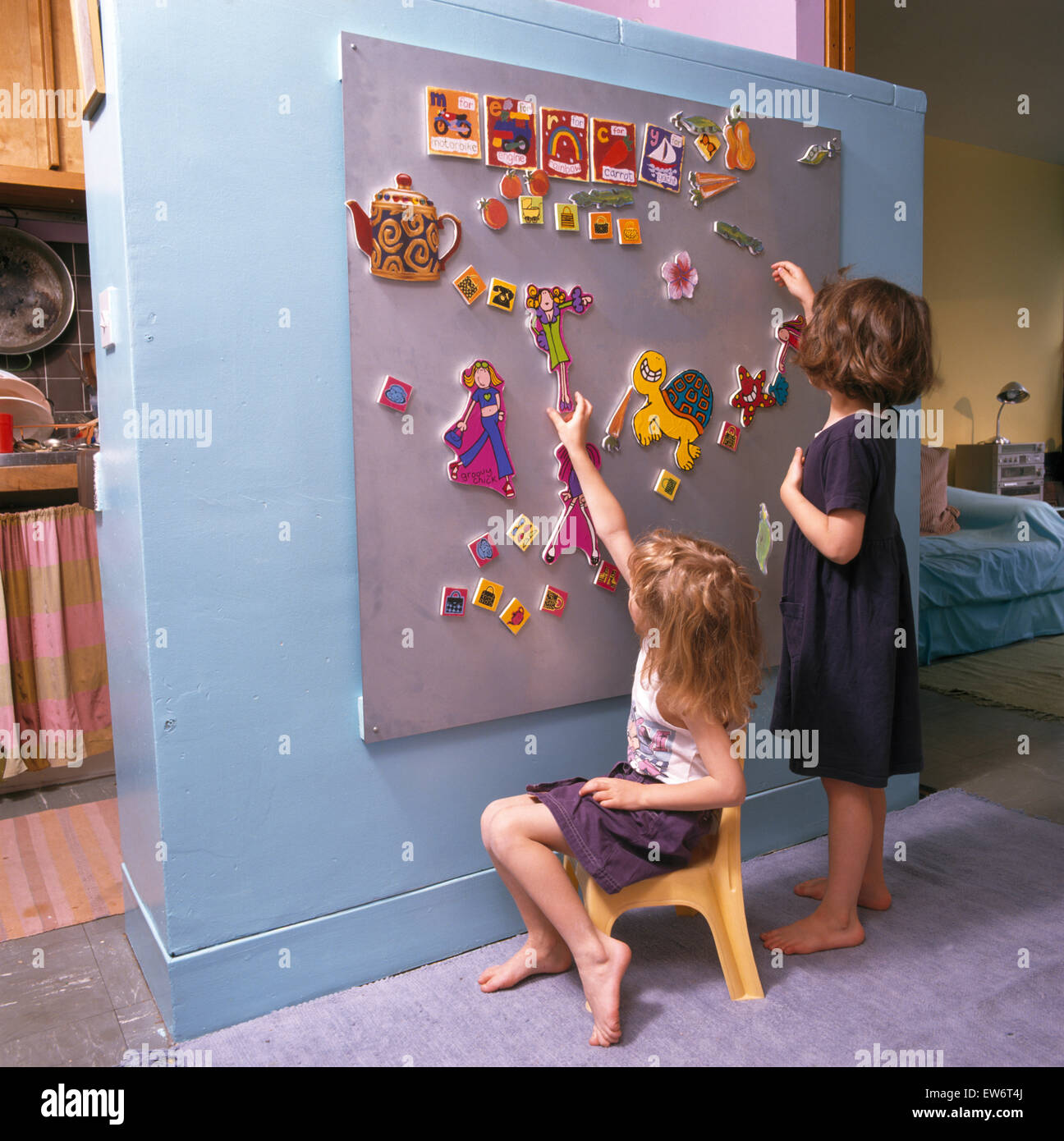 Mädchen spielen mit Formen auf einem Wandboard Stockfoto