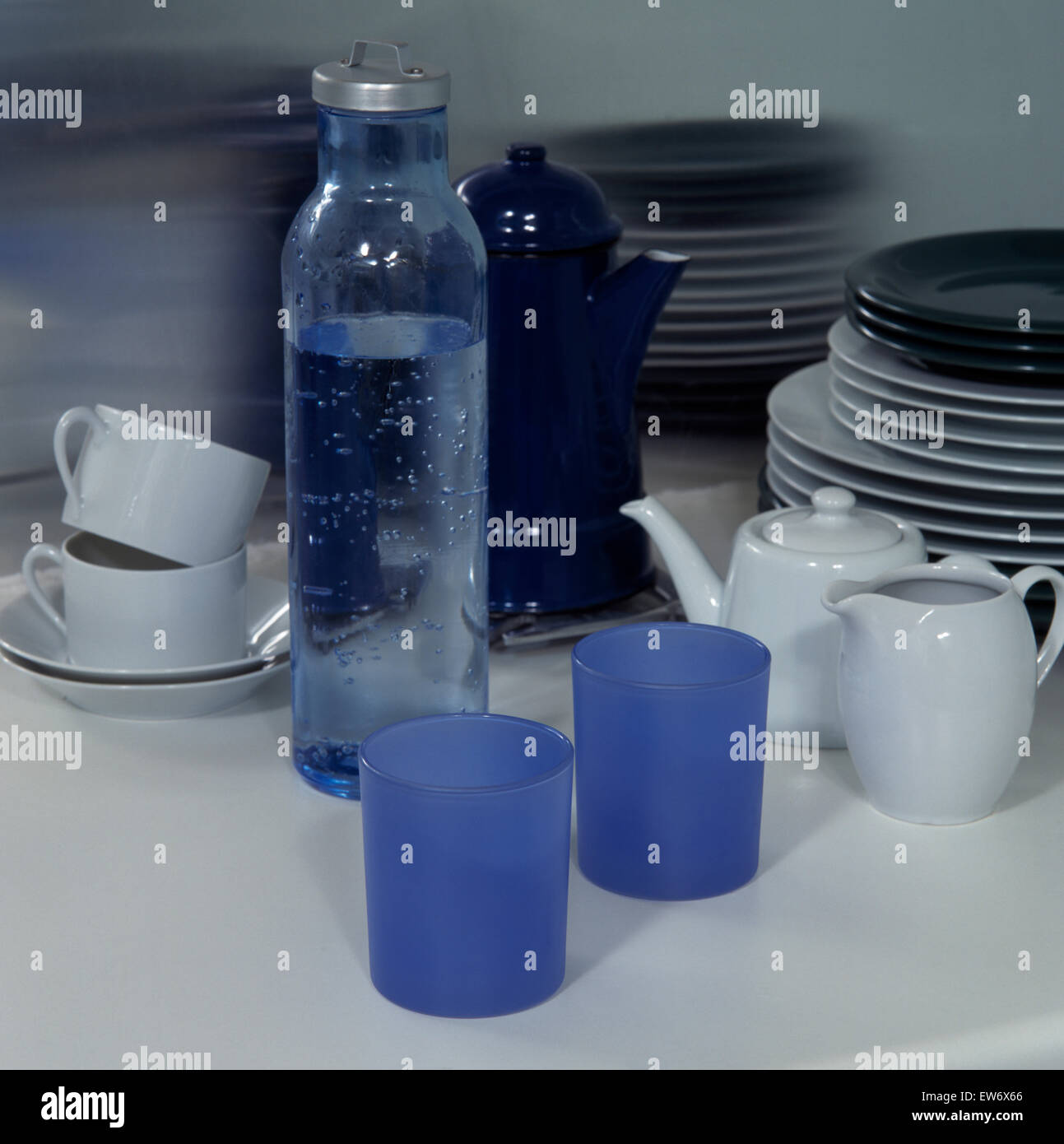 Nahaufnahme der blaue Plastikbecher mit weißen Tassen und Teekanne und eine Flasche Wasser Stockfoto