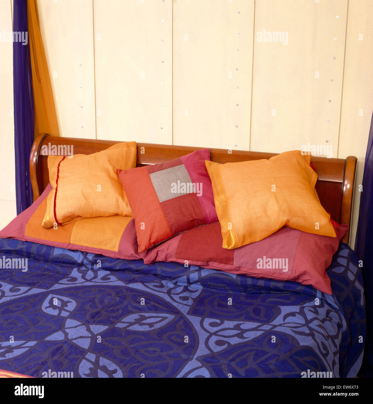 Orange Kissen im Bett im neunziger Jahre Wirtschaft Stil Schlafzimmer Stockfoto