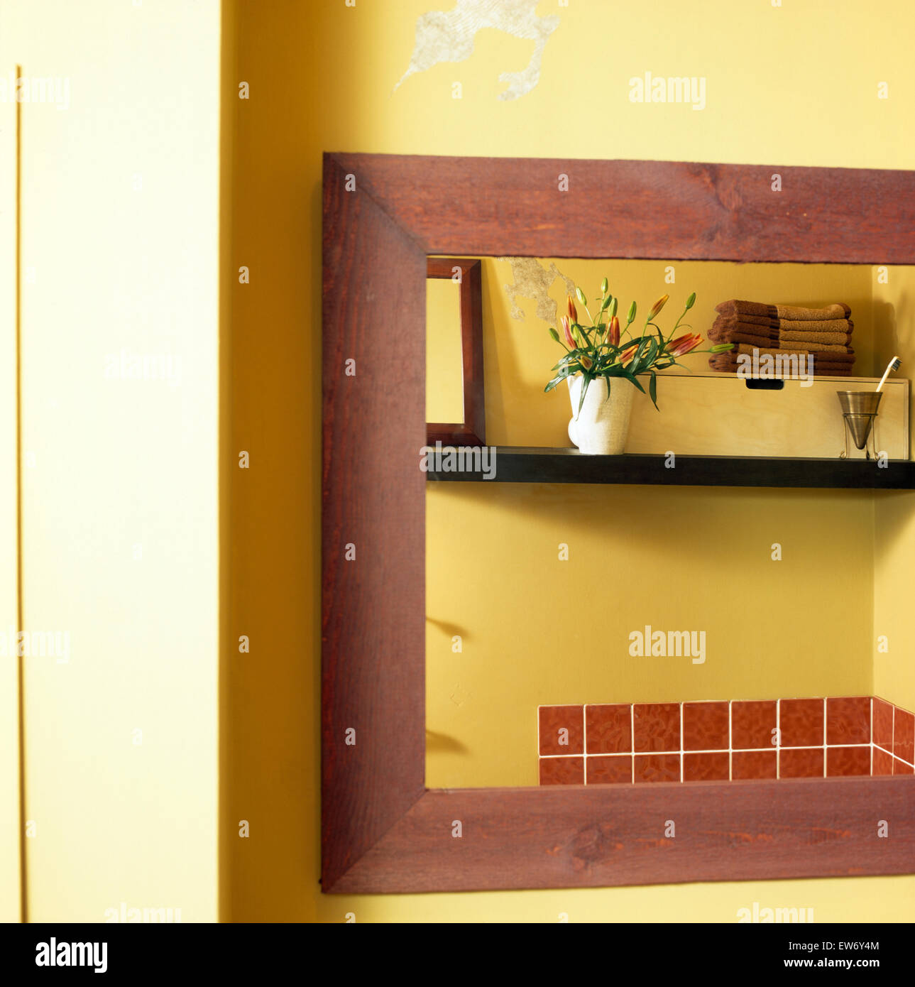 Ein Holz gerahmten Spiegel ein Detail eines gelben Badezimmers in Nahaufnahme Stockfoto