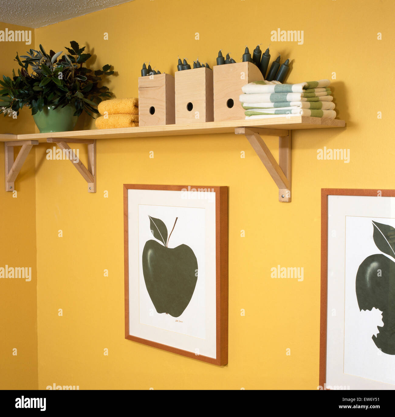 Nahaufnahme des hölzernen Aufbewahrungsbehälter auf einem grundlegenden Holzregal über Bilder von Äpfeln Stockfoto
