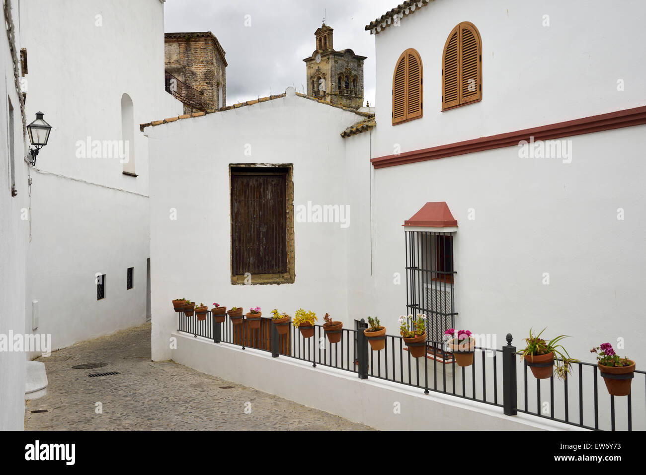 Maldonado Street, Church of Saint Peter mit weiß getünchten Häusern und Blumen in Ton Töpfe Arcos De La Frontera Spanien Stockfoto