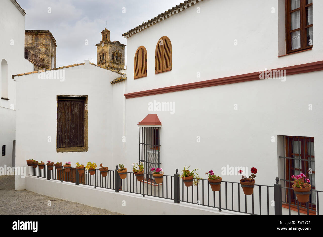 Glockenturm der Kirche des Heiligen Petrus mit weiß getünchten Häusern und Blumentöpfe in Arcos De La Frontera Spanien Stockfoto