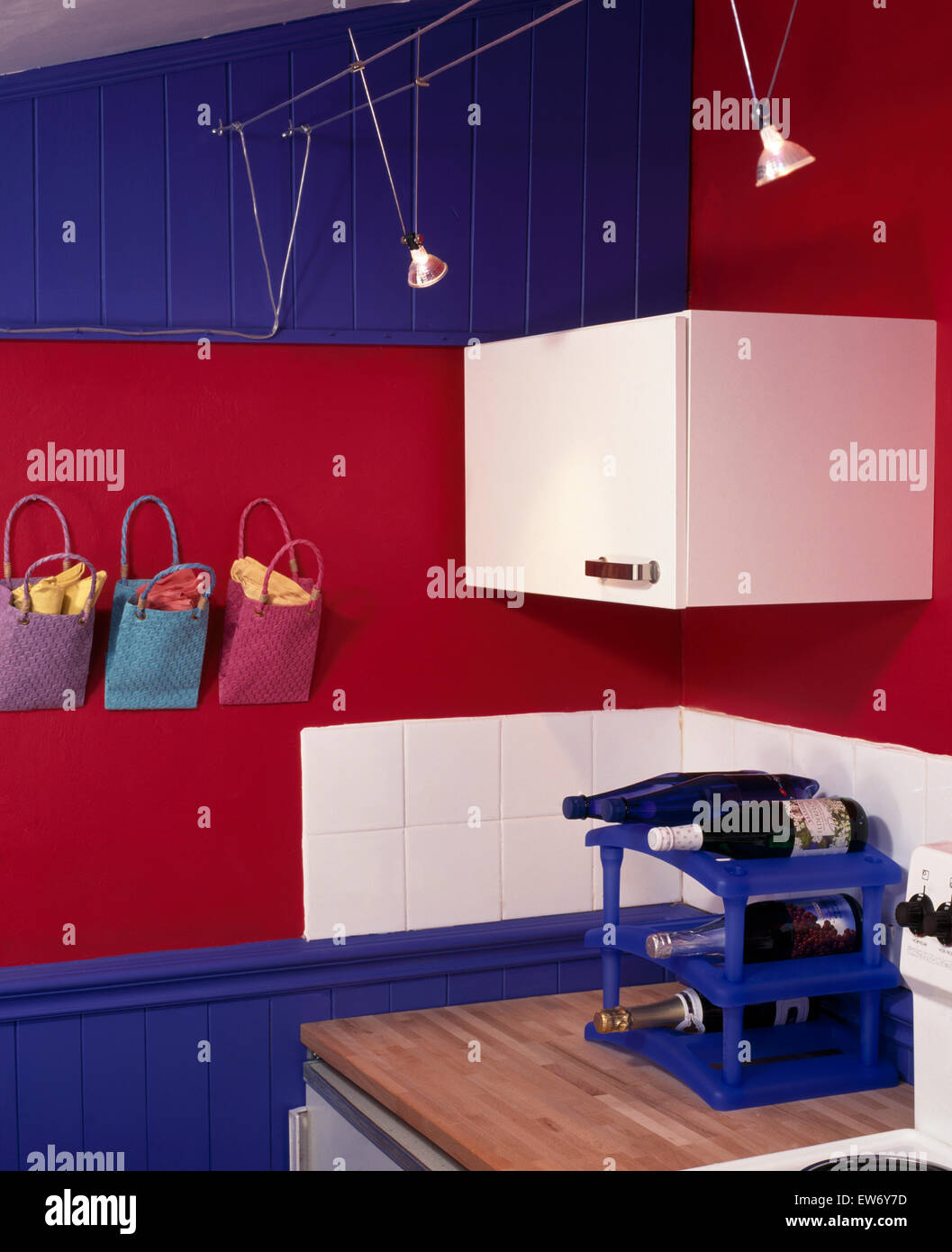 Weiß ausgestattet, Einheiten und Fliesen in einem hellen blau und rot Wirtschaft Stil Küche Stockfoto