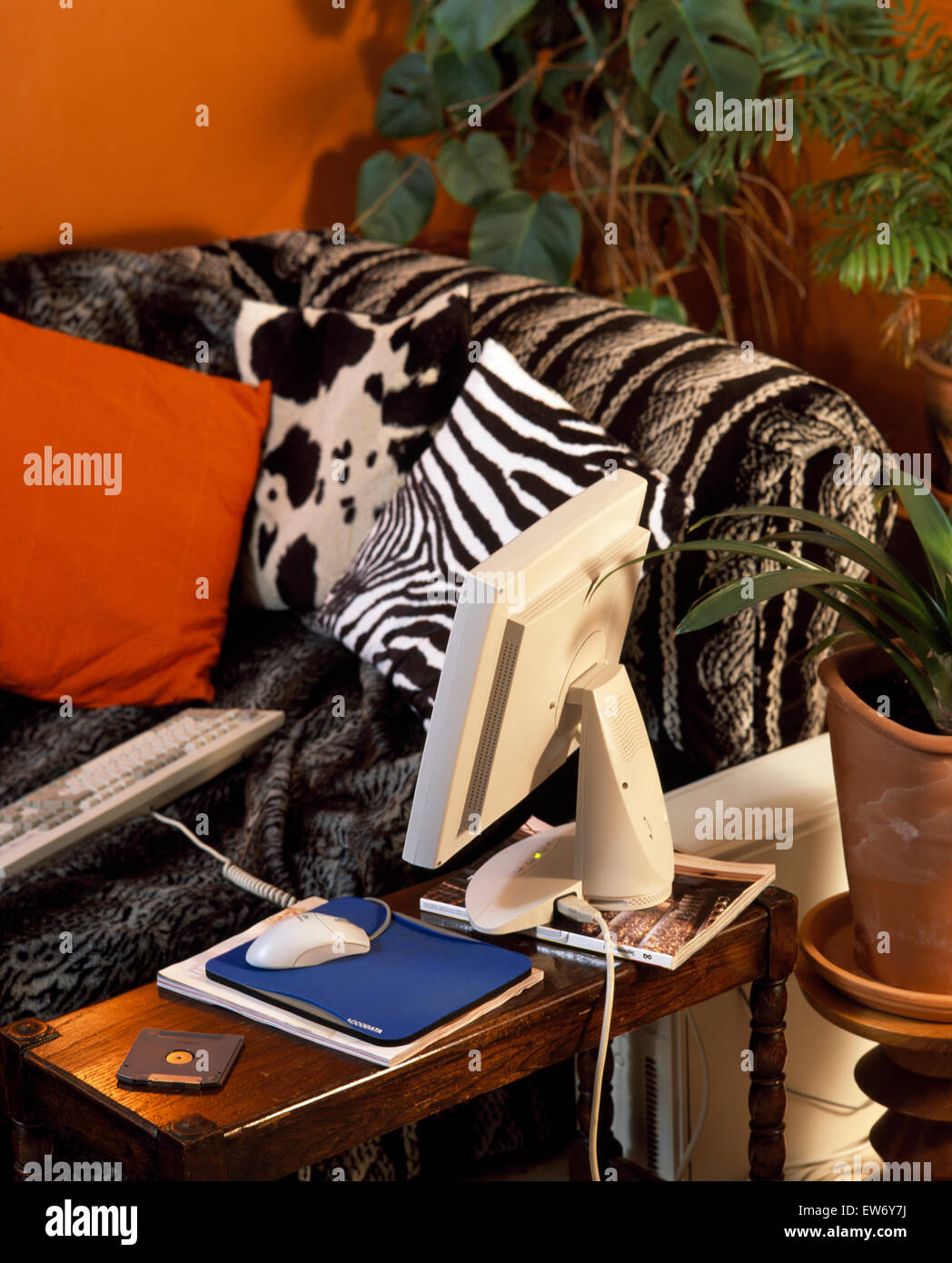 Animal print Kissen auf Sofa in einer neunziger Jahre Wohn-Schlafraum mit einem Computer auf einem niedrigen Tisch Stockfoto