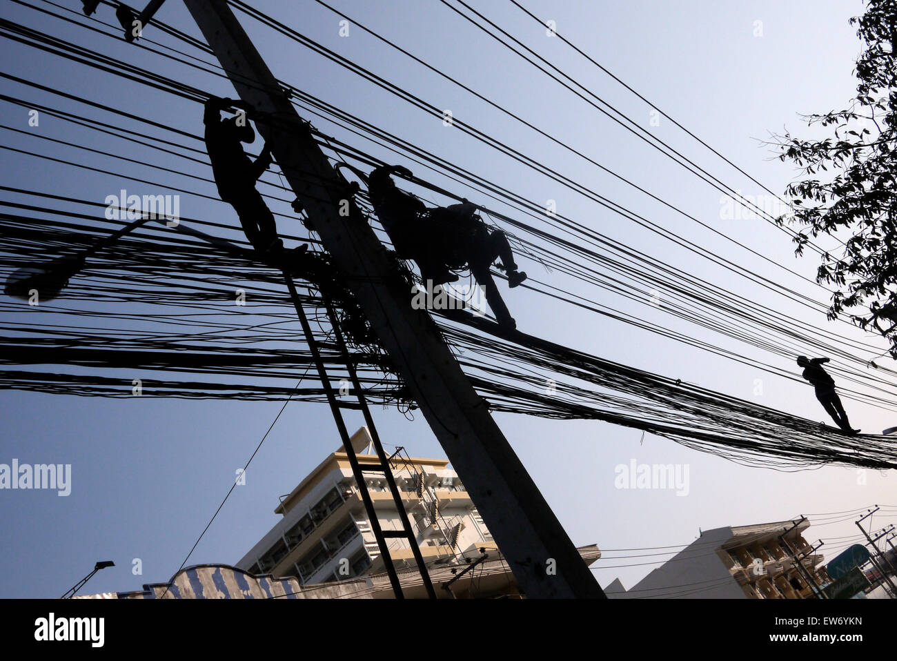 Elektrische Kabel-Monteure in einer gefährlichen Situation über einer Stadt Straße in Pattaya Thailand arbeiten Stockfoto