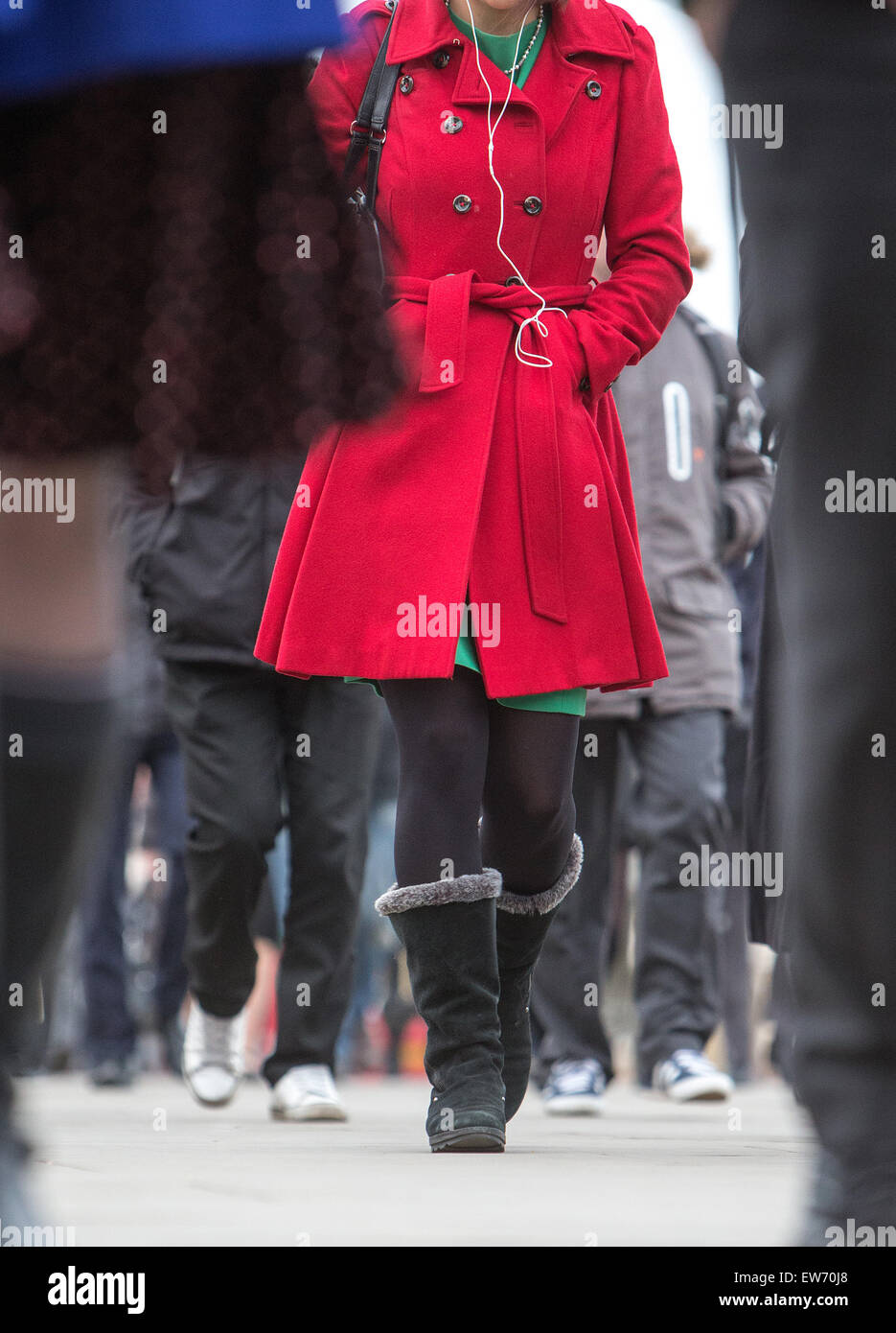 Eine Frau in einem roten Mantel zu Fuß auf dem Bürgersteig in London Stockfoto