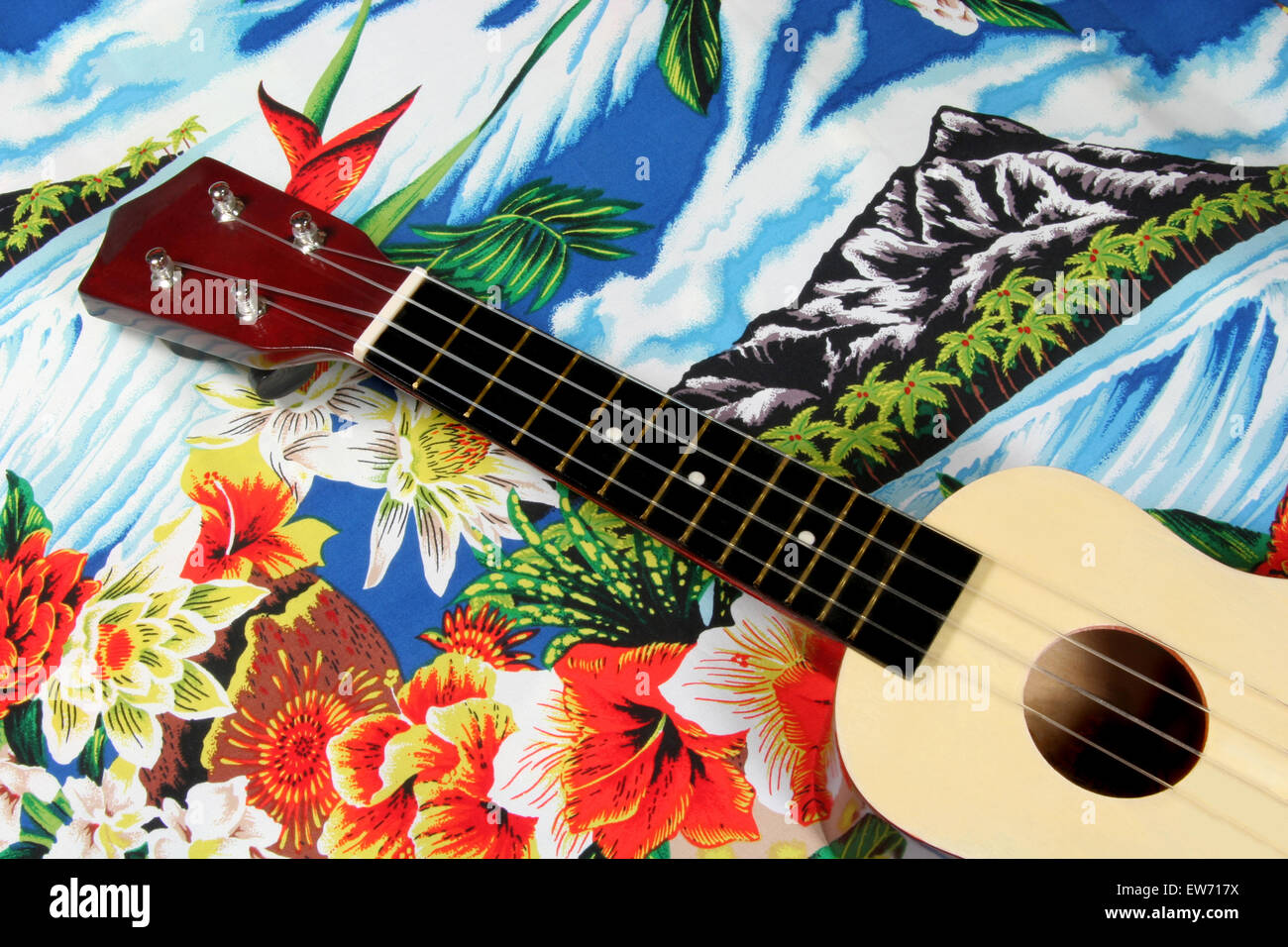 Eine Ukulele, aufgestellt auf einem typischen hawaiianischen gemusterten Stoff. Stockfoto