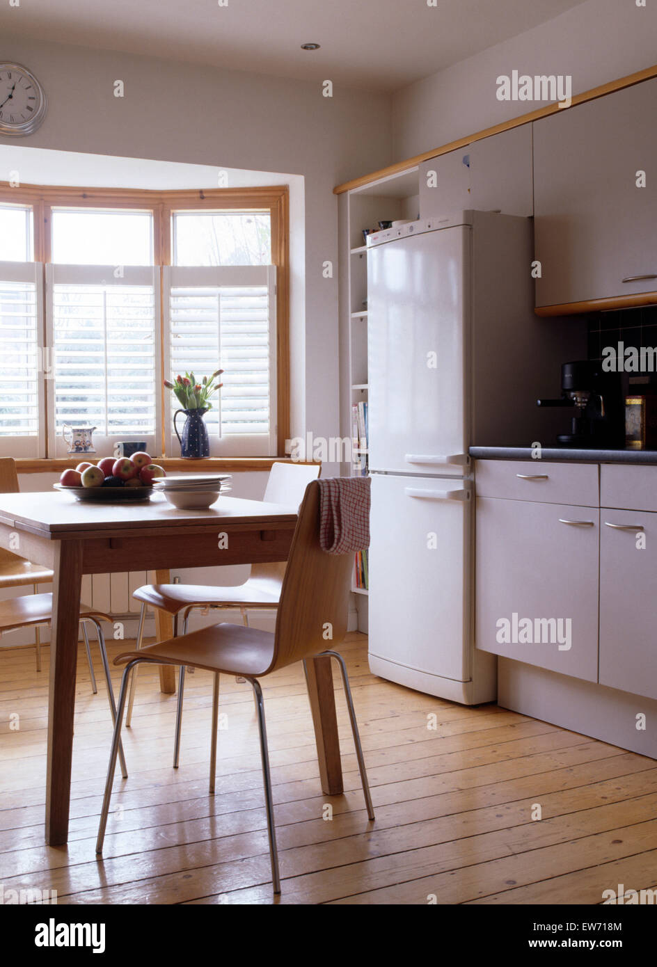 Aus Holz und Sperrholz Stühlen in modernen weißen Küche mit Holzboden und großen Kühl-Gefrierkombination Stockfoto