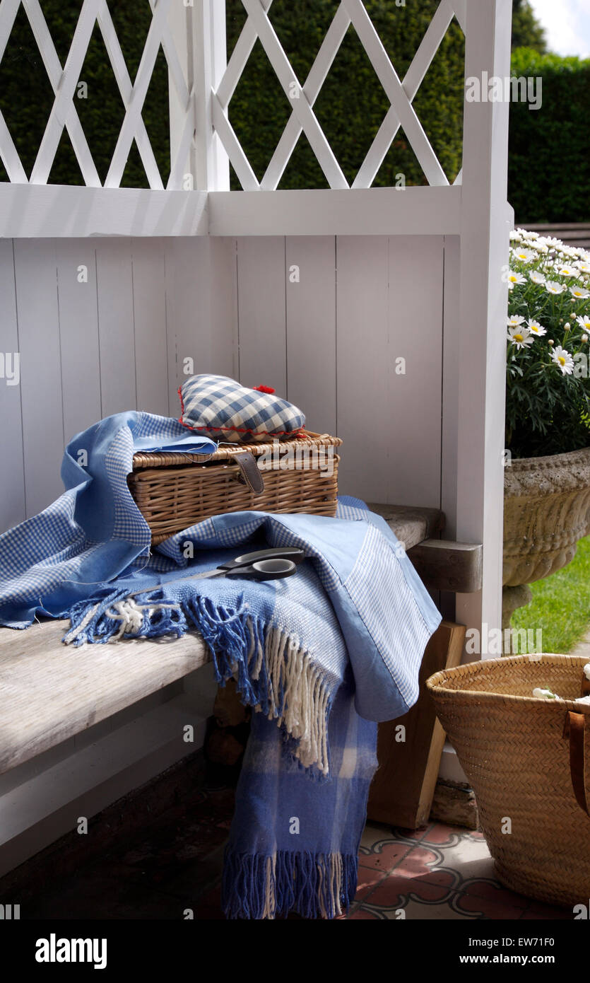 Wicker Korb und blau mit Fransen Picknickdecke auf Sitz im Inneren und weiße Holz-Pavillon Stockfoto
