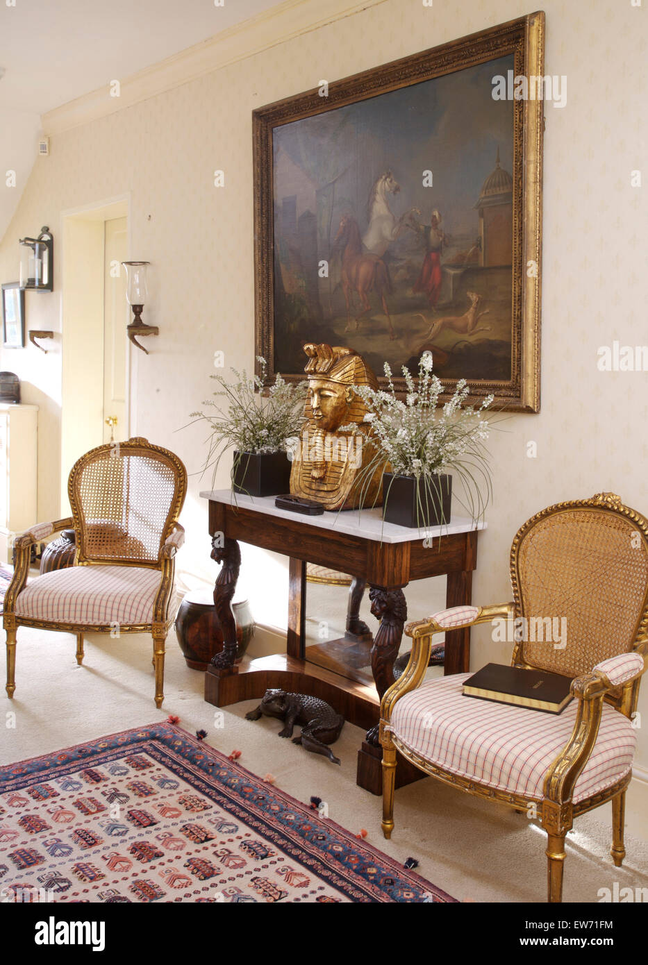 Vergoldeten französischen Stil Stühle auf beiden Seiten auf Marmor gekrönt Konsolentisch mit faux Zimmerpflanzen in traditionellen Halle Stockfoto