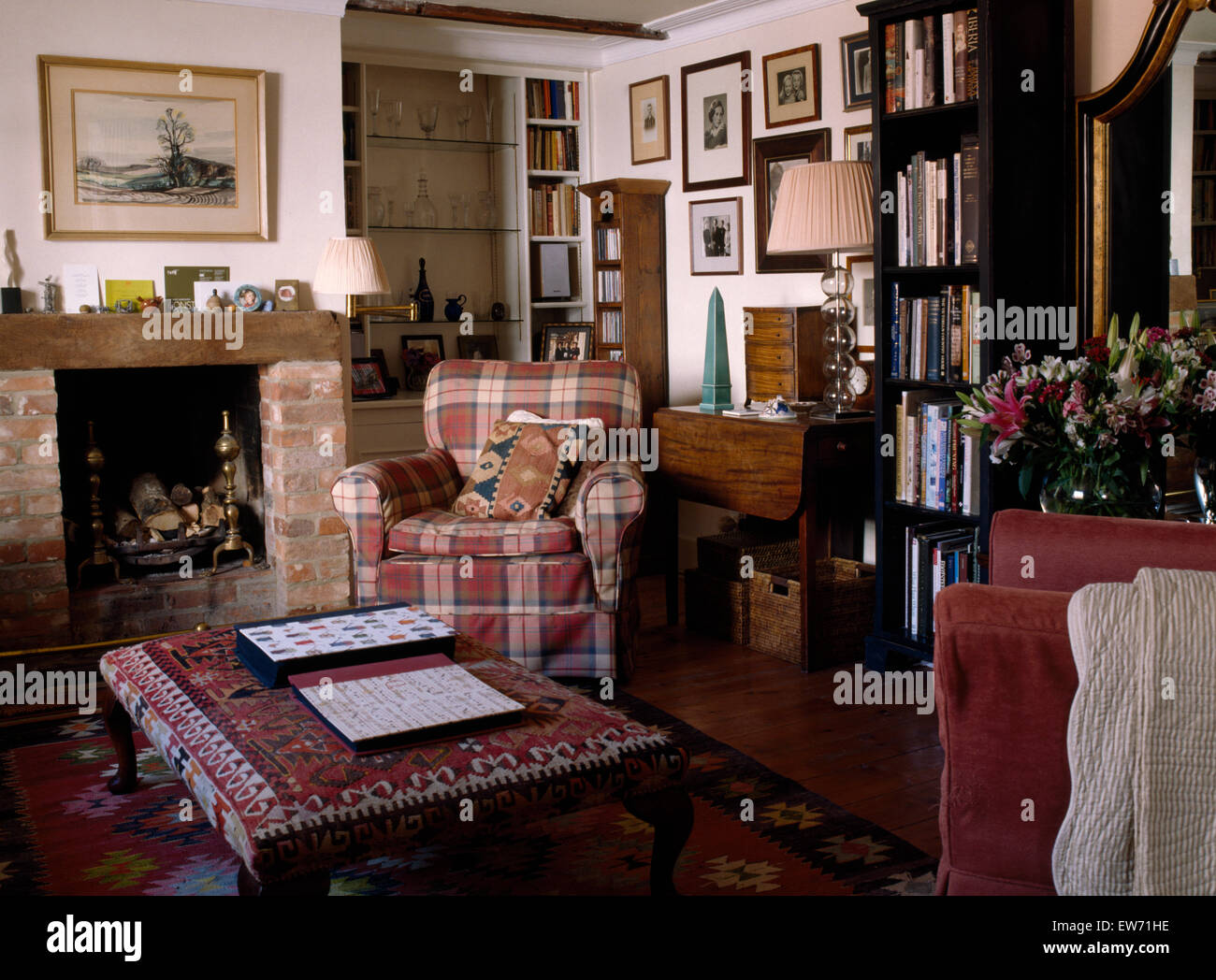 Aufgegebenen Sessel und Kelim gepolsterten Hocker im Wohnzimmer kleine Hütte Stockfoto