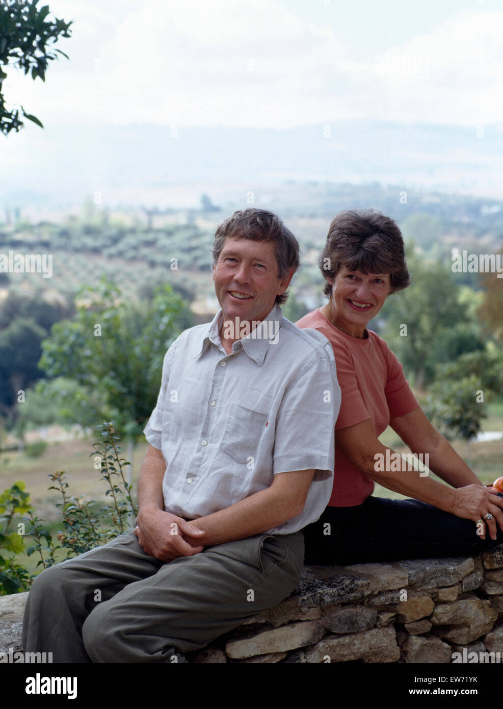 Porträt eines lächelnden Paares sitzen auf einer Steinmauer für nur zur redaktionellen Nutzung Stockfoto