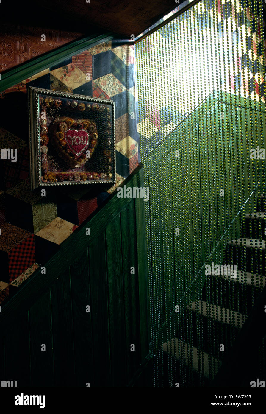 Grüne Perle Vorhang auf sechziger Jahre Treppe mit Patchwork Tapete Stockfoto