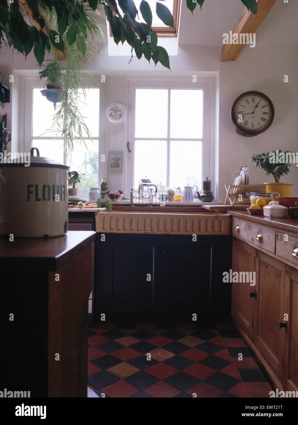 Alten Steingut sinken in traditionellen neunziger Jahre Küche mit Vintage Wanduhr und original viktorianischen gefliesten Boden Stockfoto