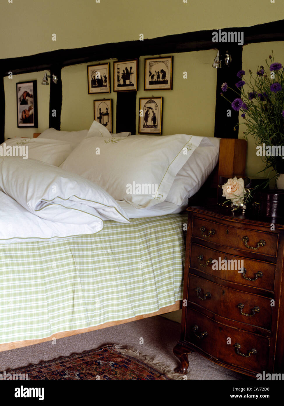 Weißen Kissen und grüne aufgegebenes Volant am Bett im Schlafzimmer Ferienhaus mit antiken Schminktisch Stockfoto