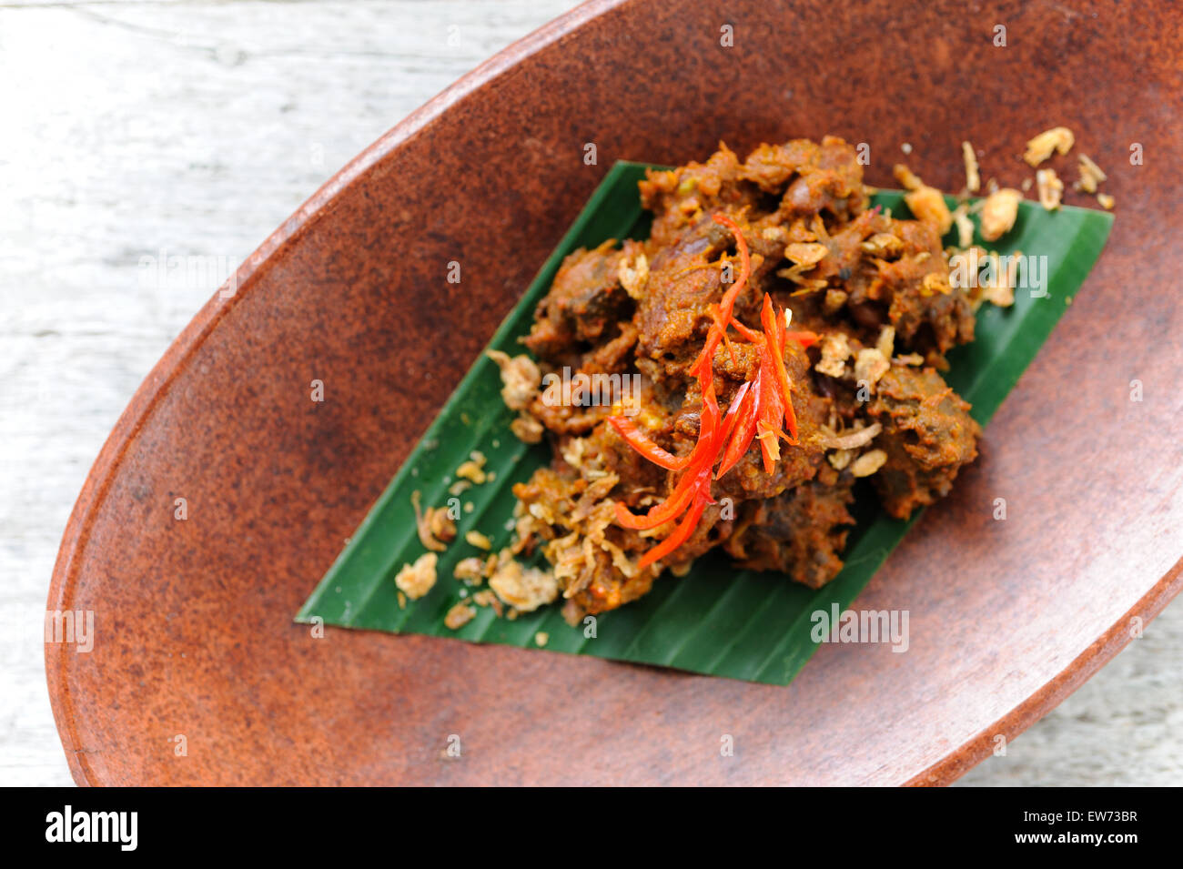 Indonesische Rindfleisch Rendang garniert mit gebratenen Schalotten und rote Chillies. Stockfoto