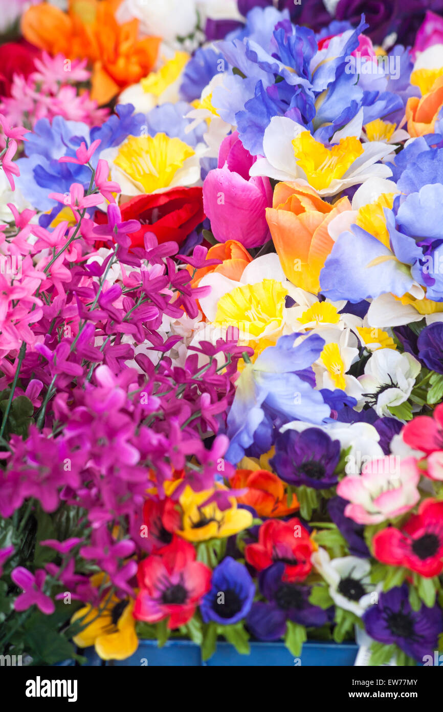 Kunstkunststoffblumen zum Verkauf am Marktstand in Dorchester, Dorset, Großbritannien im Juni Stockfoto