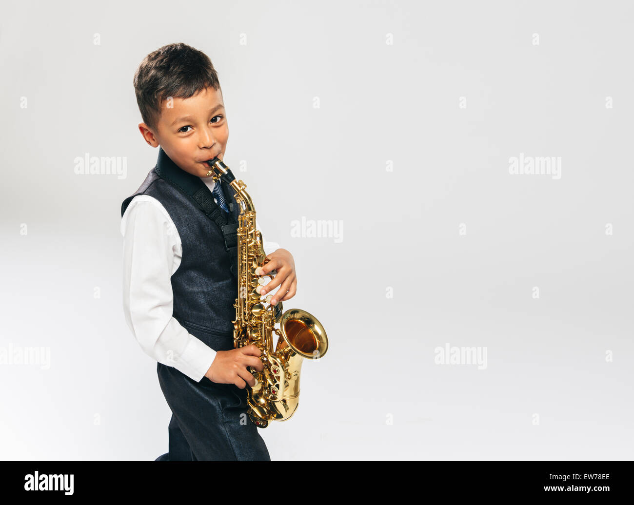 sechs Jahre alter Junge spielt Saxophon im studio Stockfoto