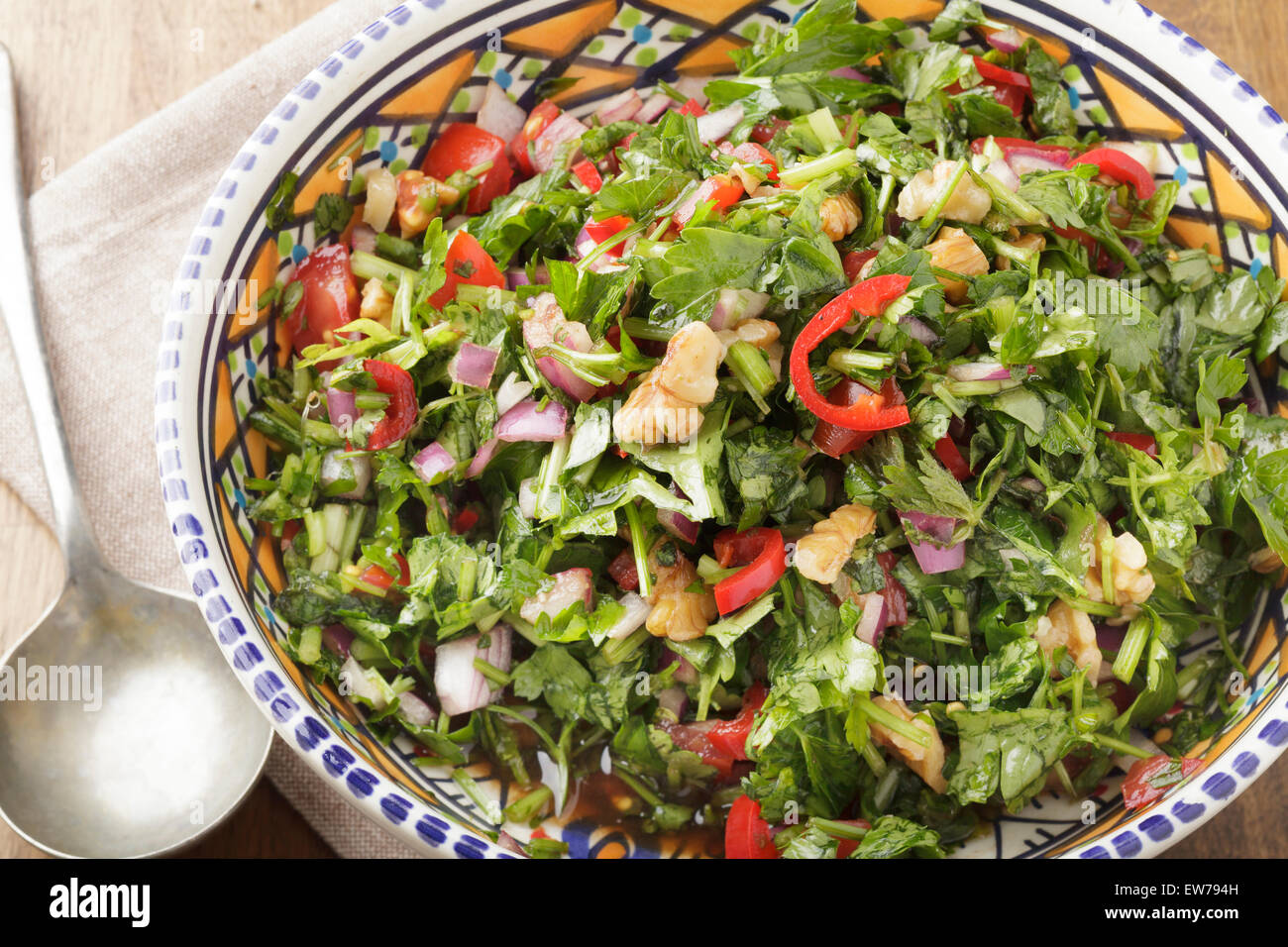 Marokkanischer Salat mit Chilis, roten Zwiebeln, Petersilie, Tomaten, Walnüsse und Granatapfel Sirup Stockfoto