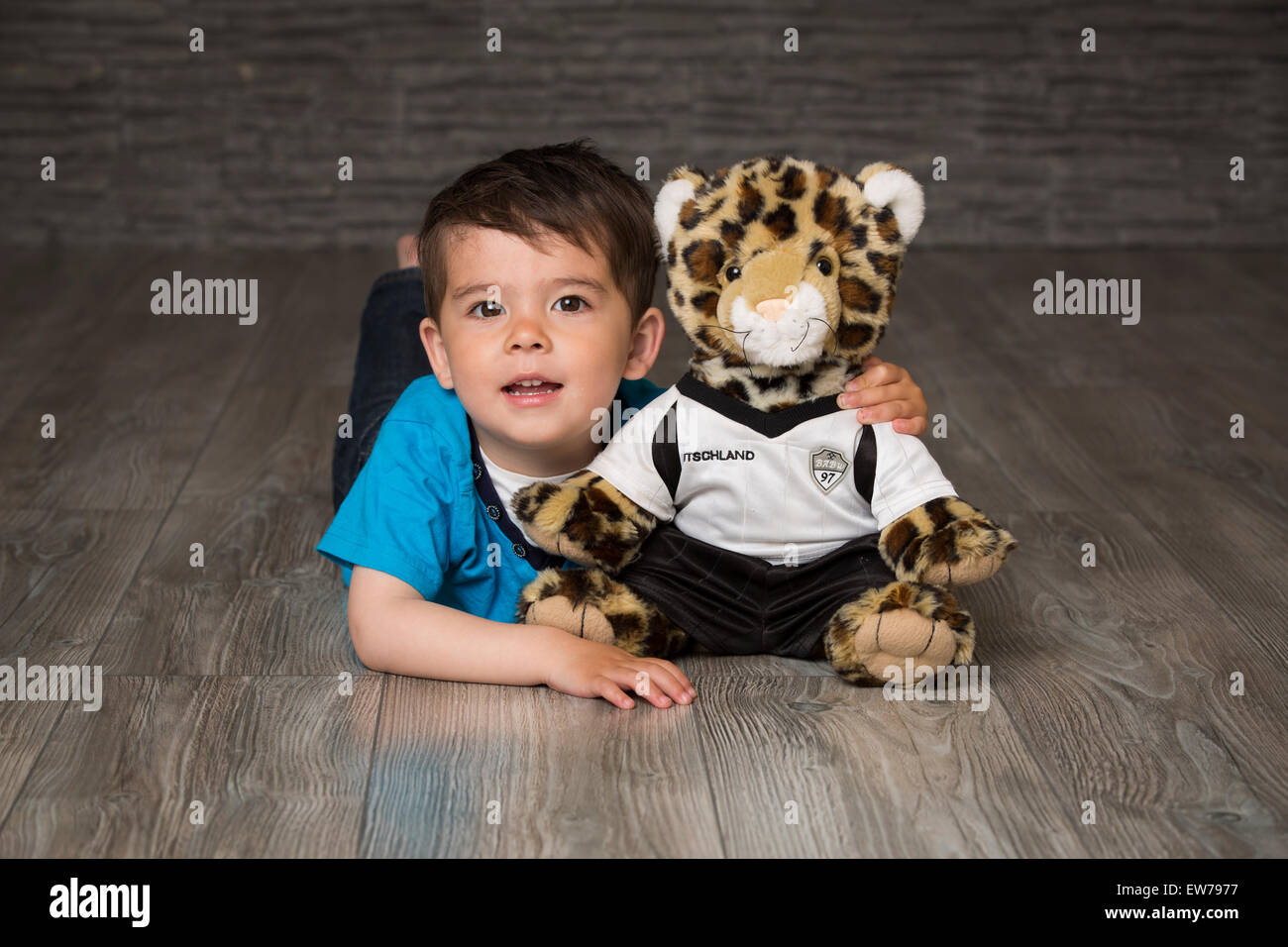 Kleiner Junge mit Kuscheltier Erdgeschoss Stockfoto