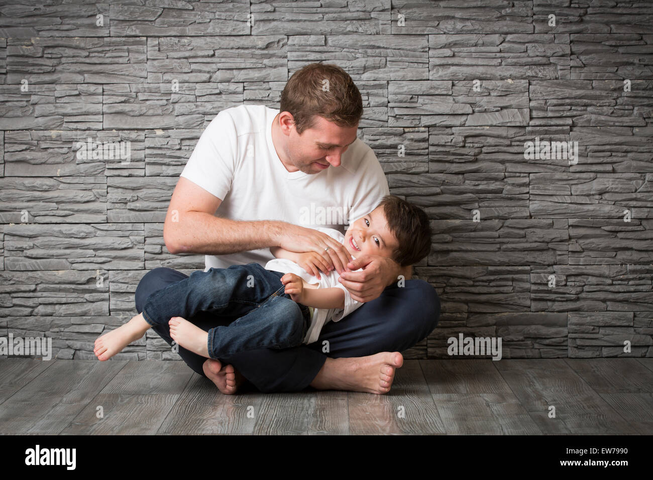 Vater kitzelt seinen Sohn Stockfoto