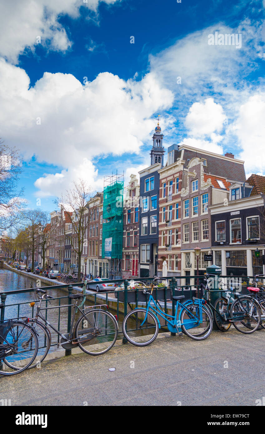 Fahrräder auf einer Amsterdam-Brücke mit einige monumentale Häuser im Hintergrund Stockfoto