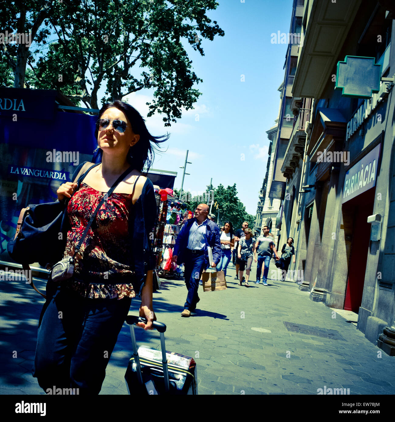 Frau zu Fuß mit einem Koffer auf Rädern. Barcelona, Katalonien, Spanien. Stockfoto