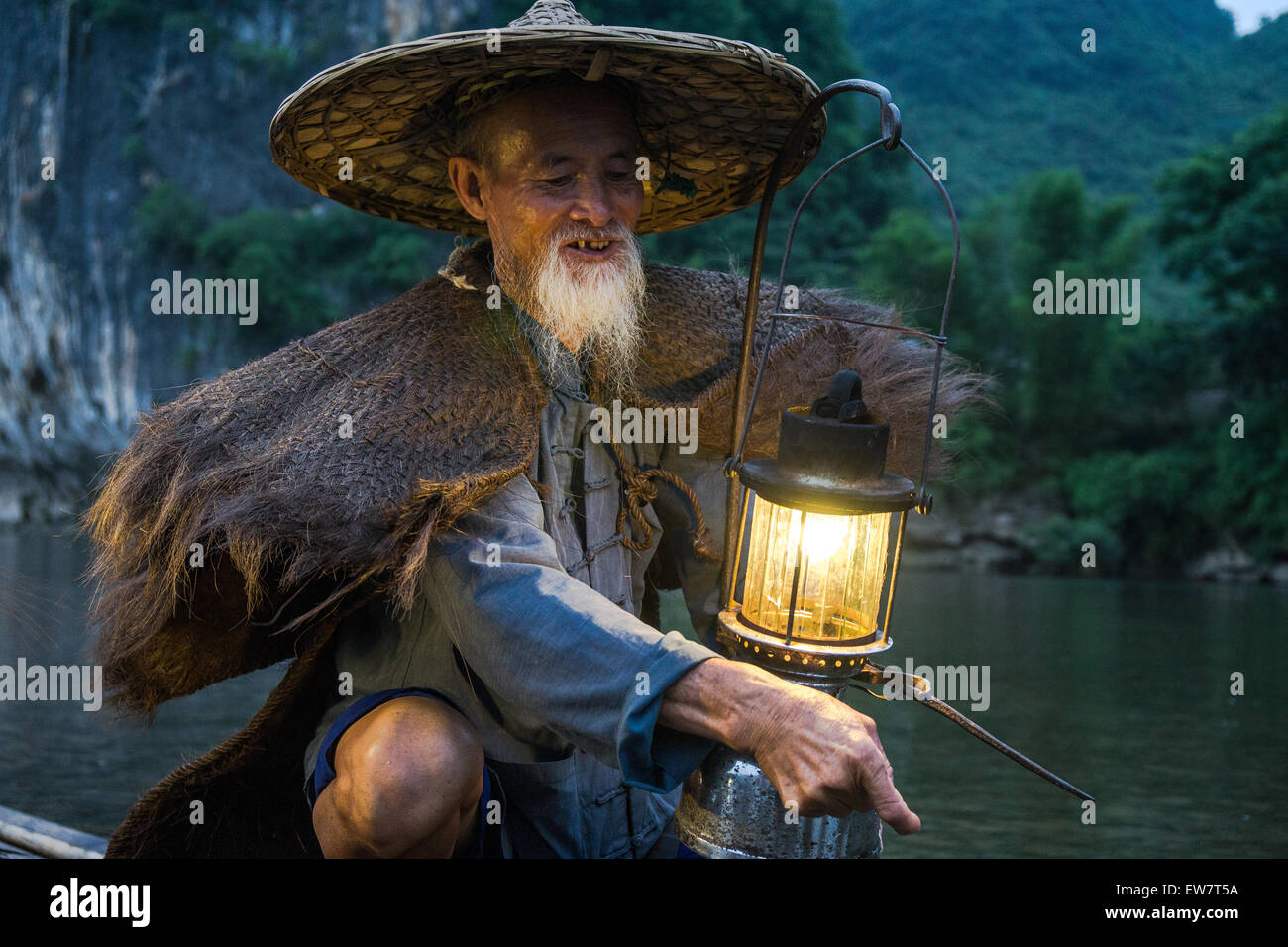 Porträt von einem alten chinesischen Fischer mit Laterne auf Bambus-Boot Stockfoto
