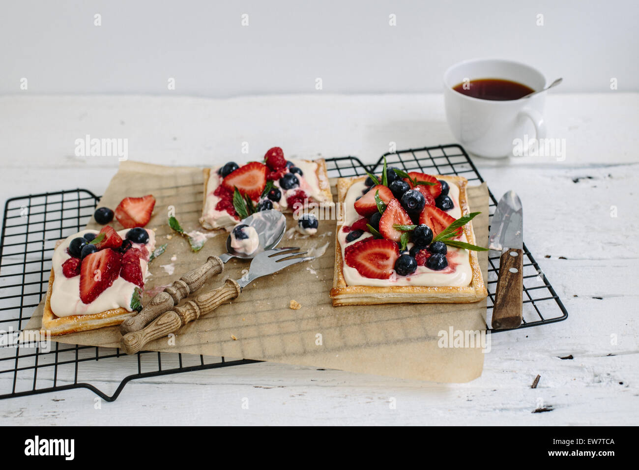Obst-Kuchen auf ein Kuchengitter mit einer Tasse Tee Stockfoto