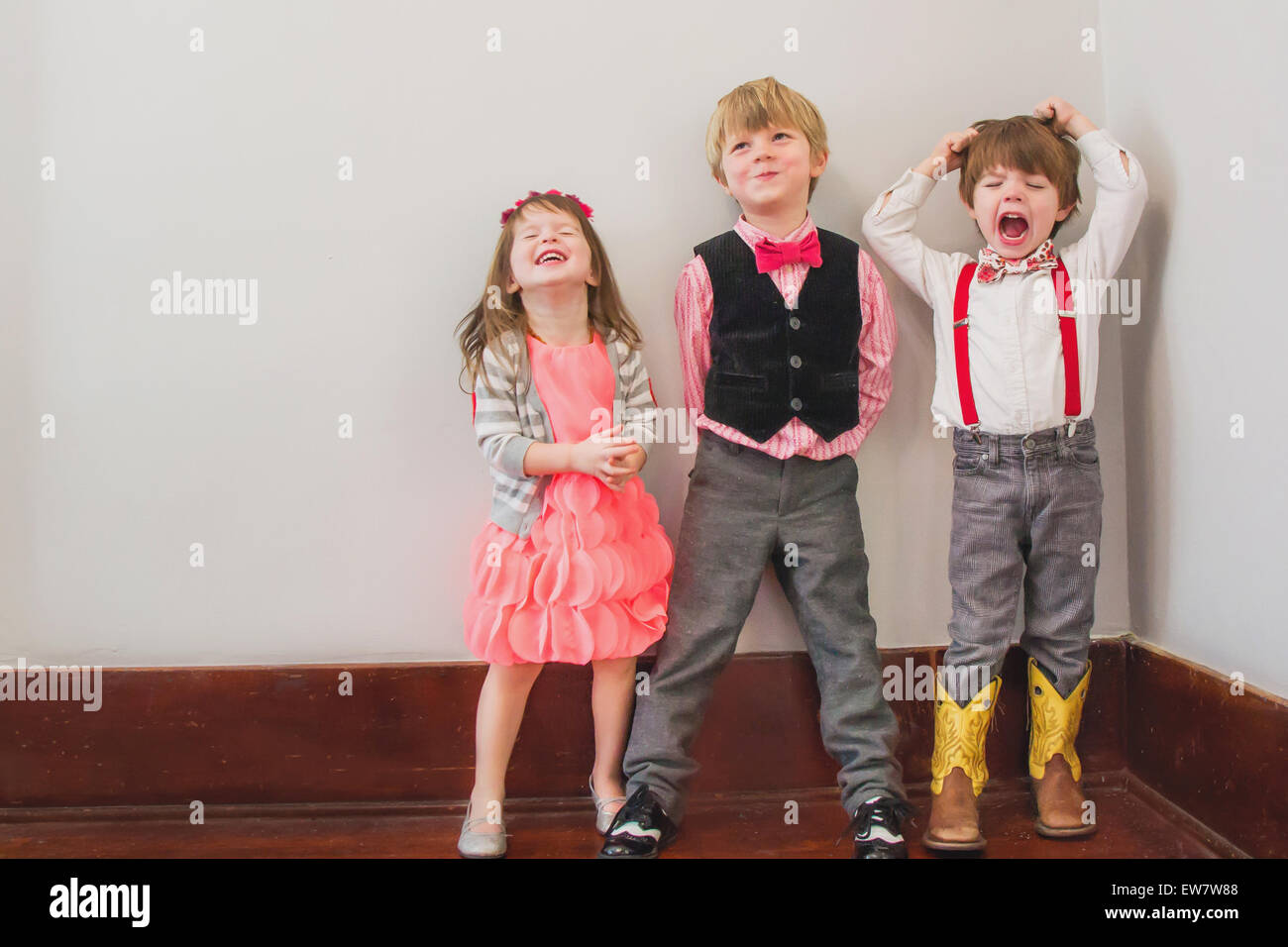 Drei Kinder in smarter Kleidung verkleidet, die herumwirren Stockfoto