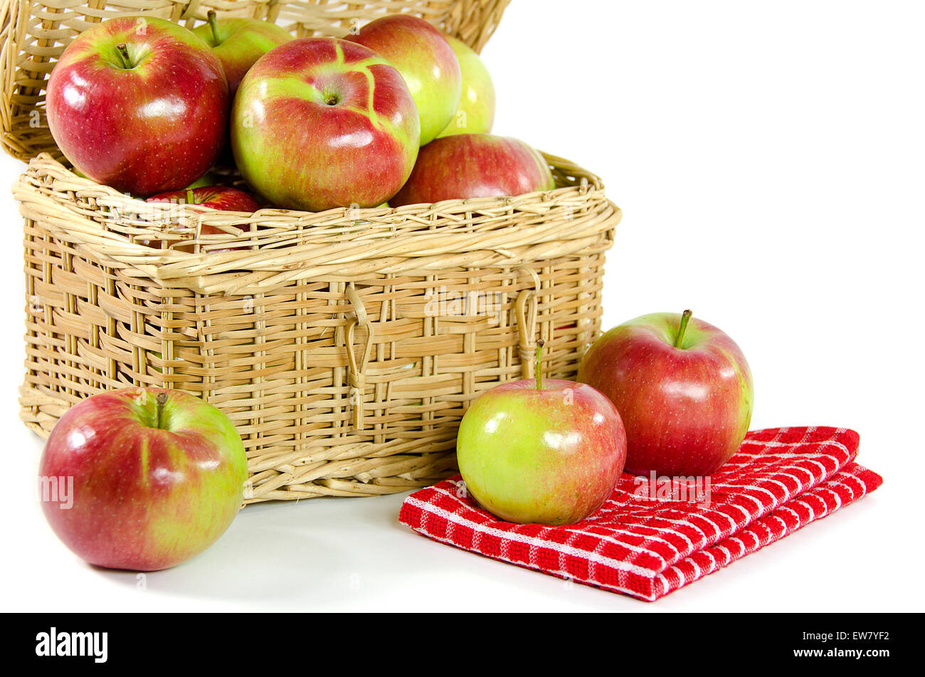 Glänzende Äpfel in einem Weidenkorb Picknick isoliert auf weiss. Stockfoto