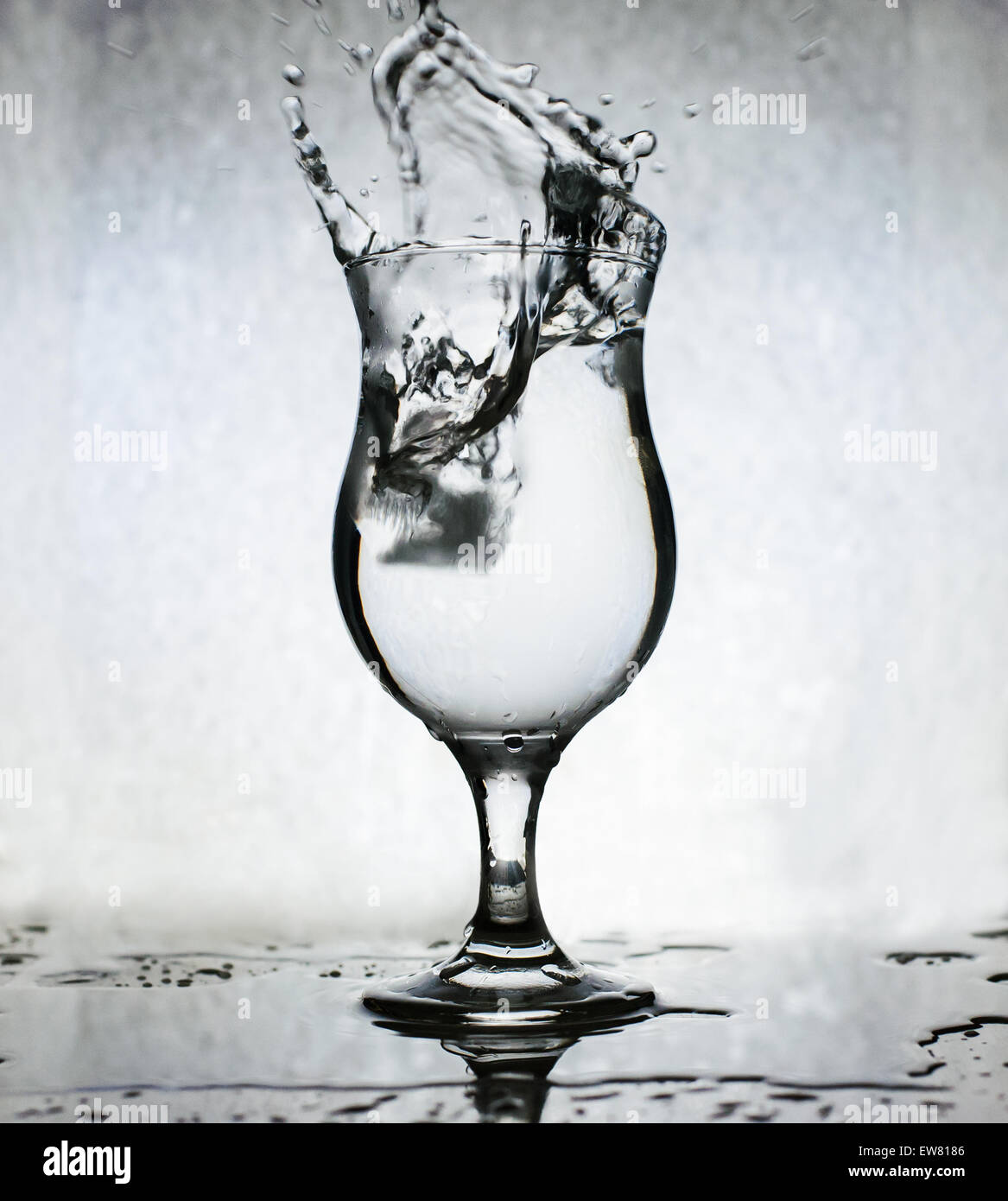 Eiswürfel ins Glas Wasser plantschen, Bewegungsunschärfe Stockfoto