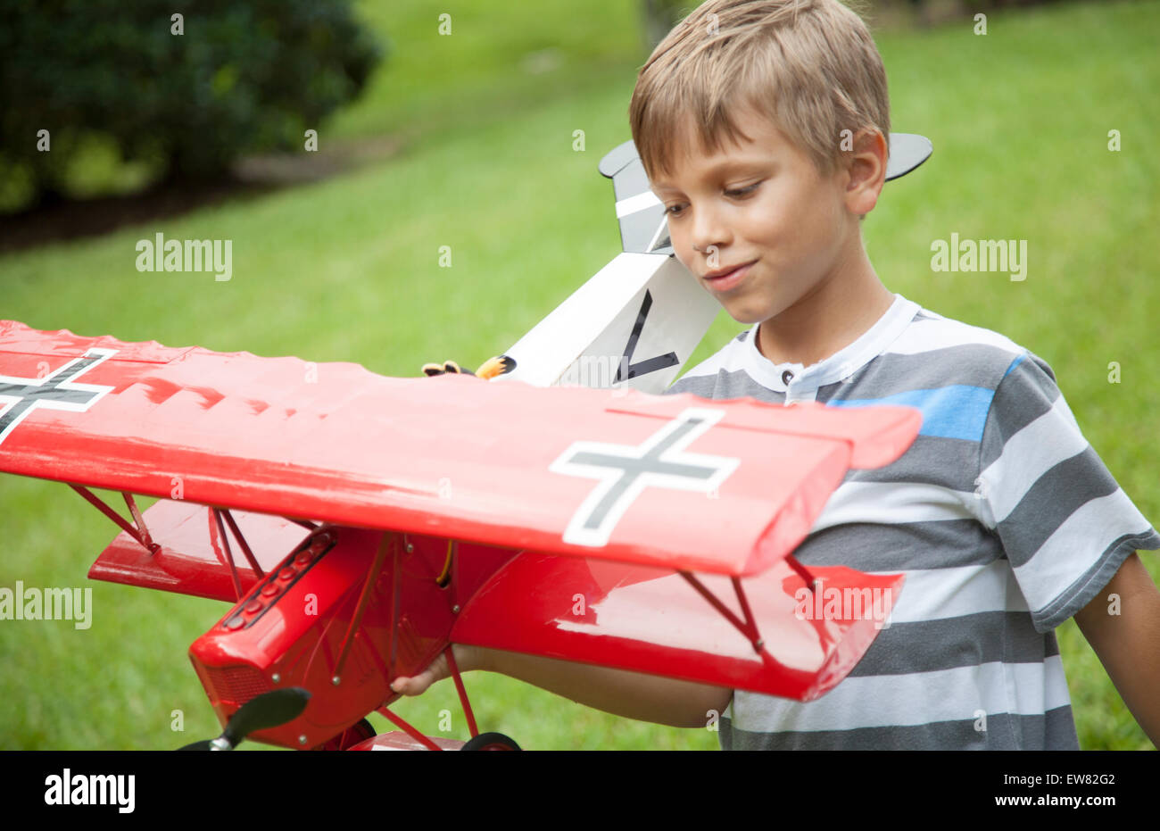 Blonde behaarte junge spielt mit Spielzeug Modellflugzeug rot Stockfoto