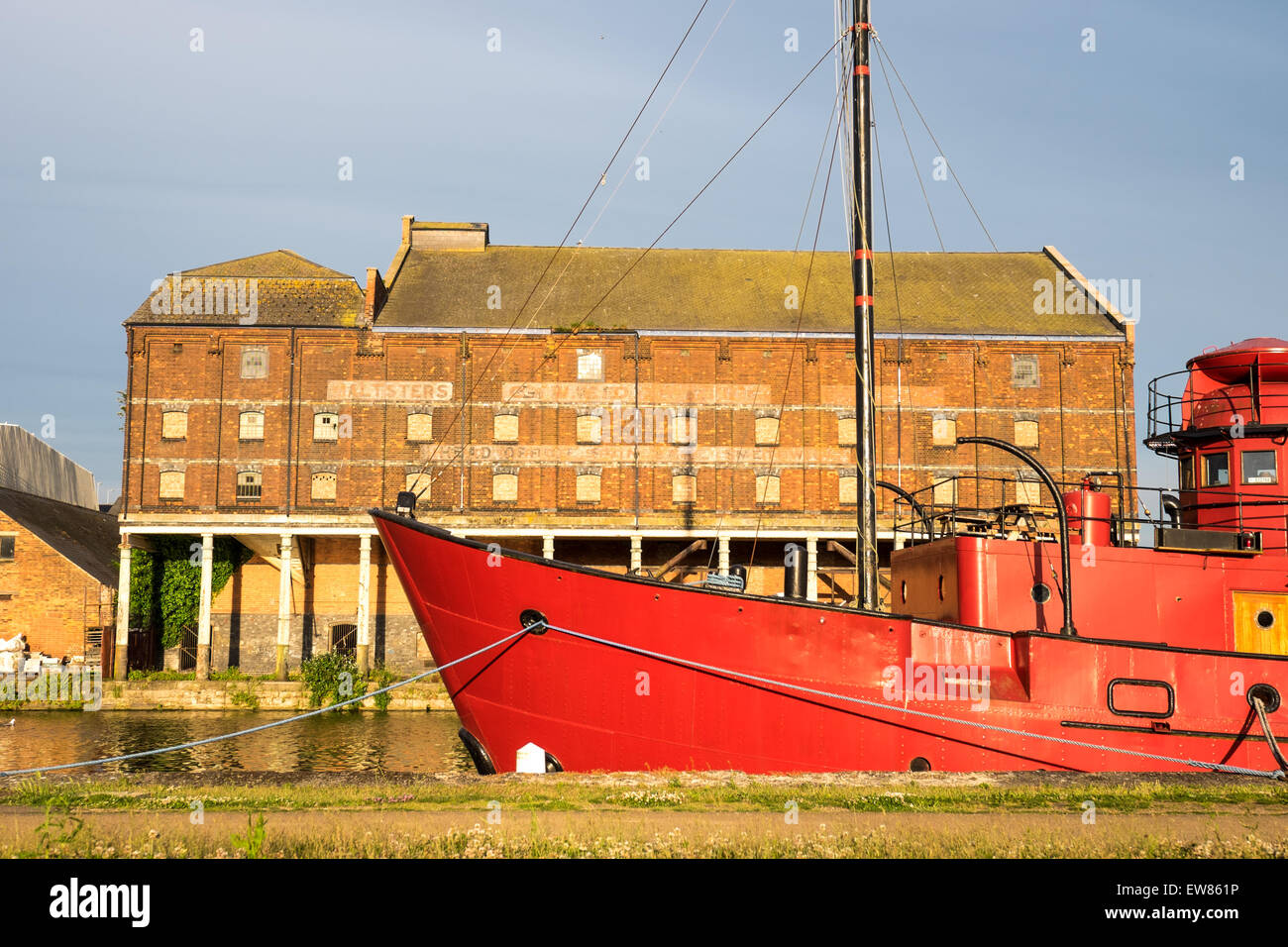 Eine rote Schiff in Gloucester Docks mit Lager im Hintergrund Stockfoto