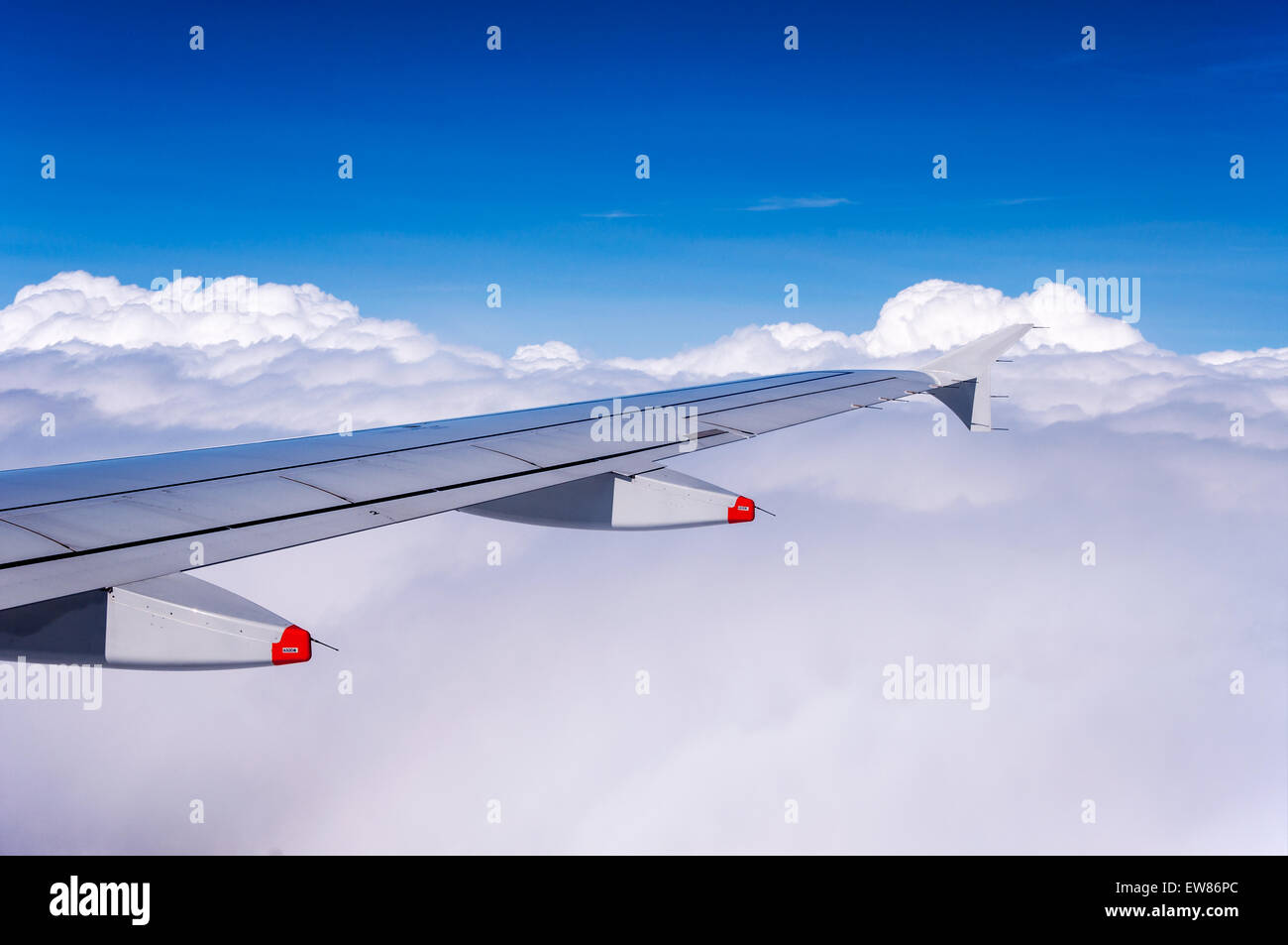 Flugzeugflügel über den Wolken mit Winglet und zwei Anti-Schock-Körper, die auch als Klappe verfolgen Verkleidungen Stockfoto