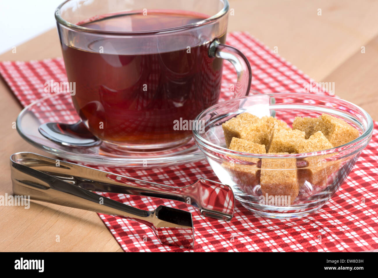 brauner Rohrzucker und einer Tasse Tee auf dem Tisch Stockfoto