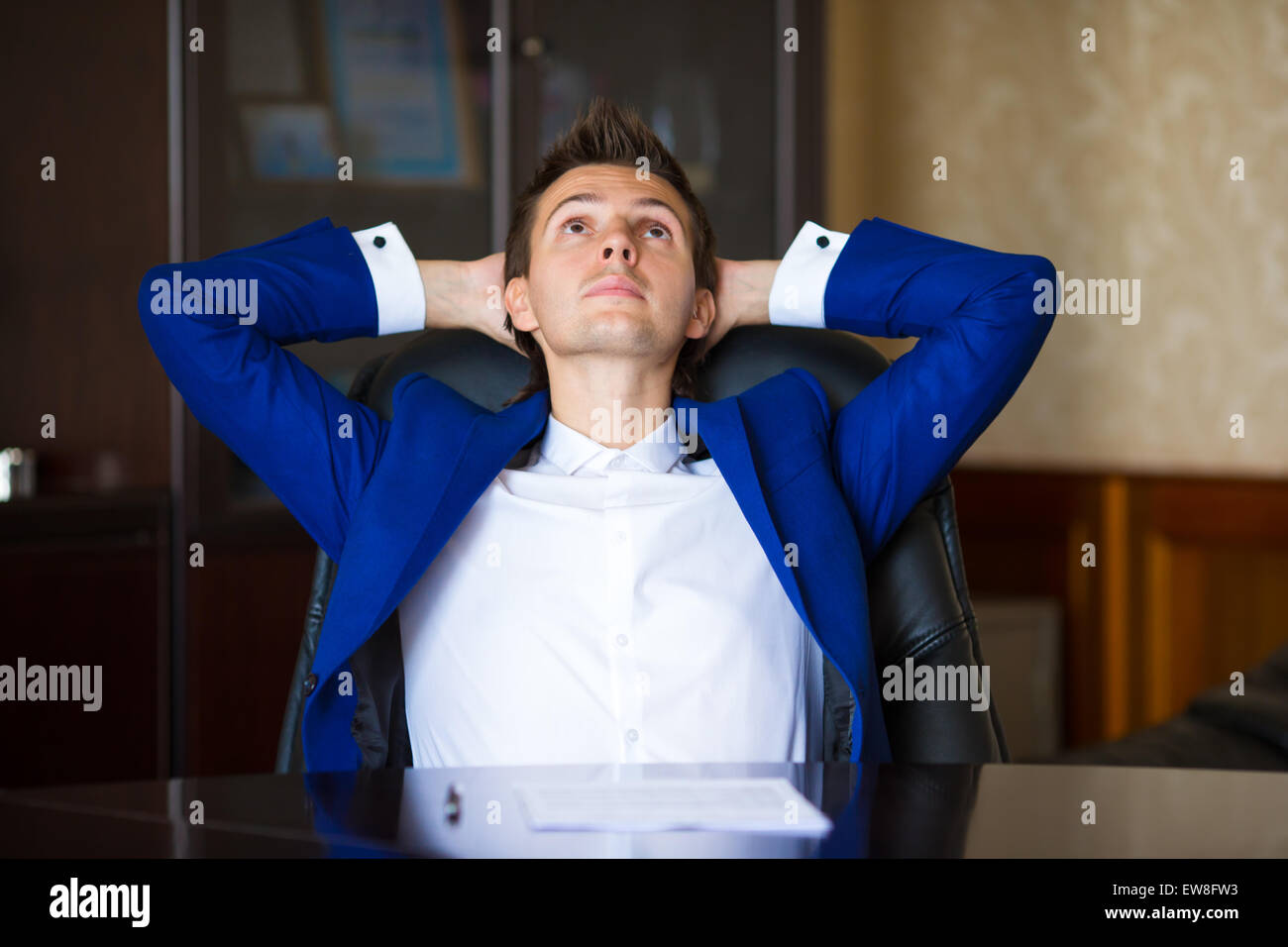 Geschäftsmann in seinem Sessel im Büro entspannen Stockfoto