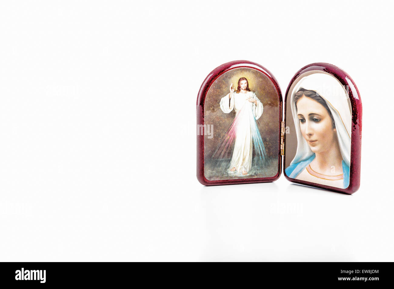 Symbole im Holzetui abgerundeten des Barmherzigen Jesus und unsere Liebe Frau von Medjugorje, isoliert der seligen Jungfrau Maria auf weißem Hintergrund mit Matte Reflexion auf weißen Tisch. Stockfoto