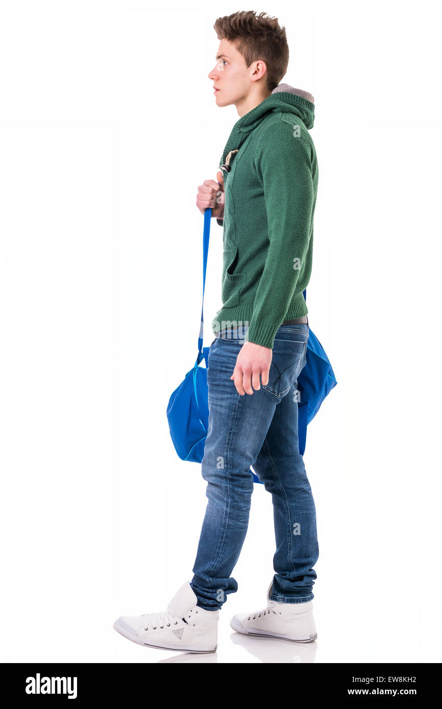 Attraktive trendige jungen Mann mit Tasche am Schultergurt, isoliert auf weißem Hintergrund, zu Fuß nach links Stockfoto