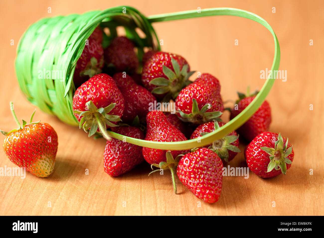 verschüttete Erdbeere mit Korb am Küchentisch Stockfoto