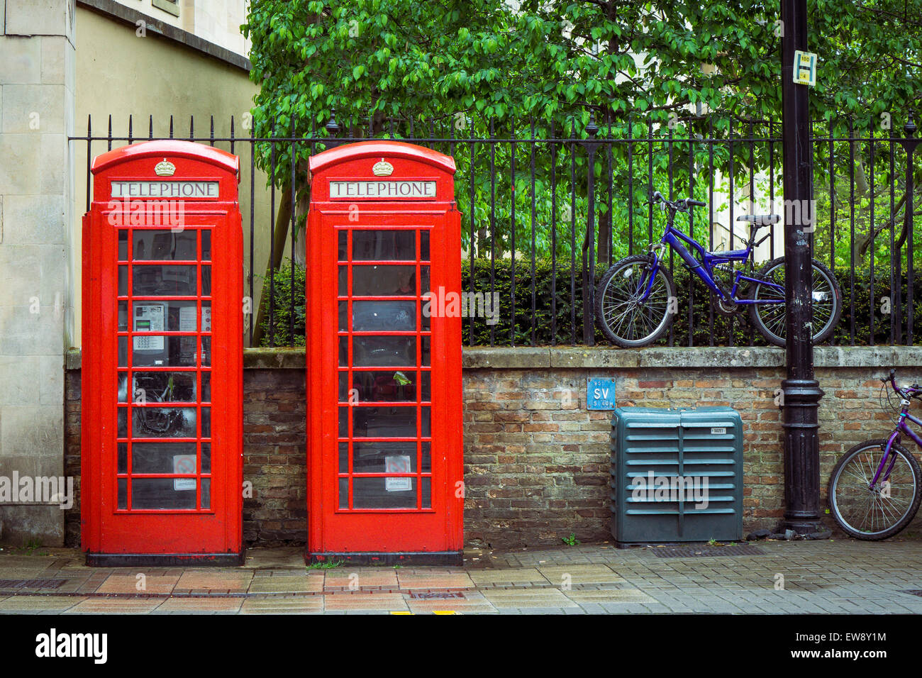 Zwei rote British Telefon Boxen und Fahrräder im Hintergrund Stockfoto