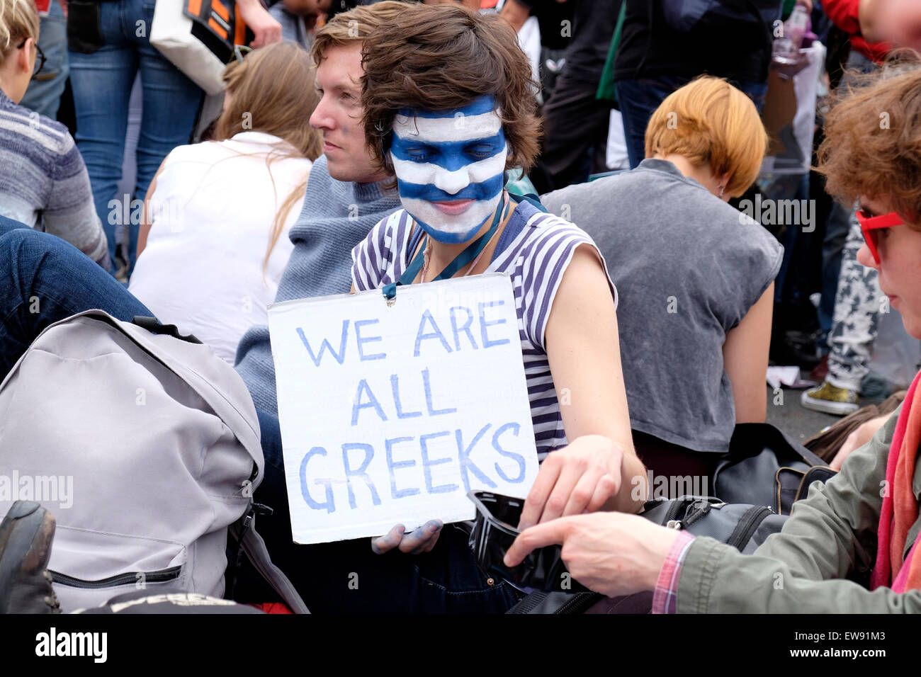 Eine Frau mit einer griechischen Flagge gemalt im Gesicht, hält ein Plakat lesen "Wir sind alle Griechen" Stockfoto