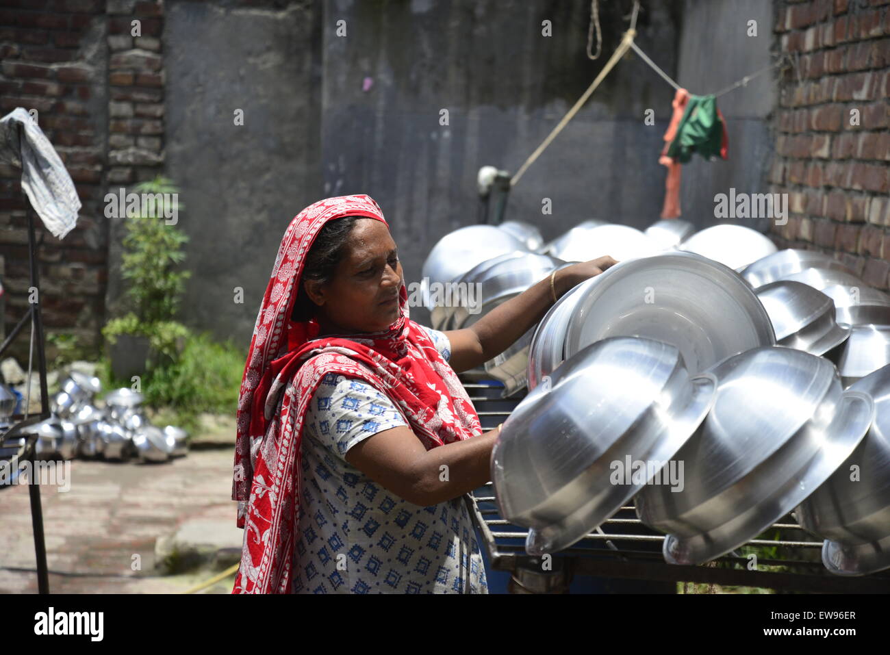 Bangladeshi manuelle Frauen arbeiten arbeitet in einer Aluminium-Topf-Making-Fabrik, jede Arbeit zu verdienen nur 300 Taka (US$ 3,87) pro Tag in Dhaka, Bangladesch. Am 20. Juni 2015 Stockfoto