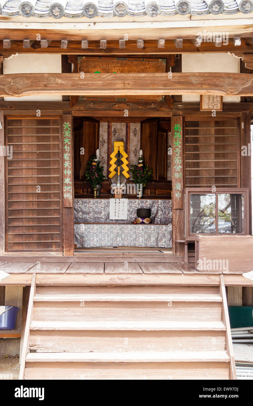 Japan, Onomichi, Taisanji Tempel. Schritte, die bis zum kleinen Schrein mit Altar und Gelb gohei Papierstreifen kontrastieren mit dem Gegerbten Holz. Stockfoto