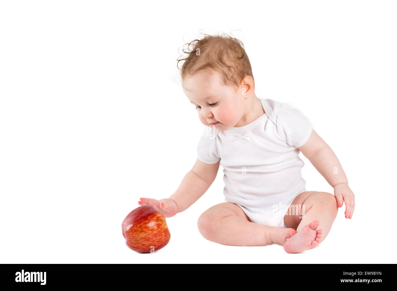 Lustige kleine Baby spielt mit einem großen roten Apfel, isoliert auf weiss Stockfoto