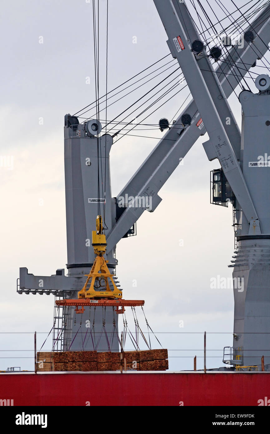 Kräne hieven Bauholz für den Export an Bord eines Frachters, Nanaimo, Vancouver Island, BC Stockfoto